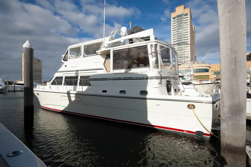 Slide: The Image of 2007 Novatec 55 Islander CPMY yacht docked at marina with cityscape background. - 2