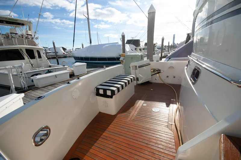 Slide: The Image of 2007 Novatec 55 Islander CPMY yacht deck with striped seating, docked at marina. - 3