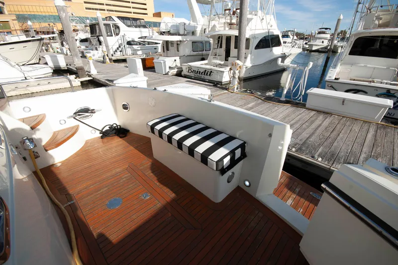 Slide: The Image of 2007 Novatec 55 Islander CPMY yacht docked at marina with wooden deck and striped seating. - 4