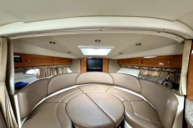Slide: The Image of 2008 Chaparral Signature 330 interior with circular leather seating and wood accents. - 17