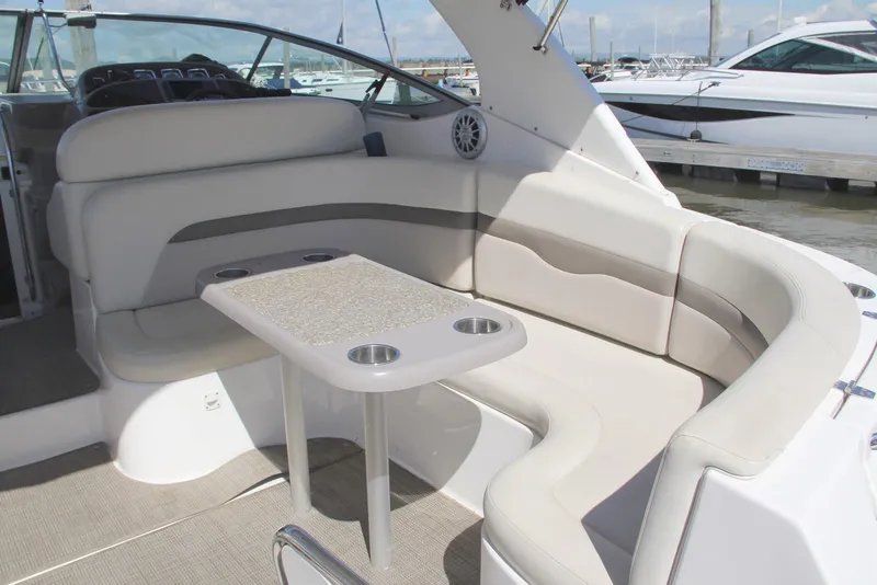Slide: The Image of 2008 Chaparral Signature 330 boat interior with beige seating and table, docked at marina. - 7