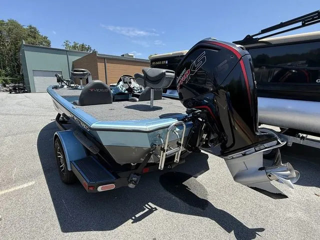 Slide: The Image of 2021 Vexus AVX1880 boat with powerful outboard motor, parked outdoors on a sunny day. - 2