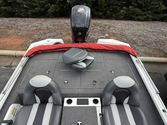 Slide: The Image of 2022 Vexus AVX1880 boat interior with seating and motor, parked outdoors. - 14