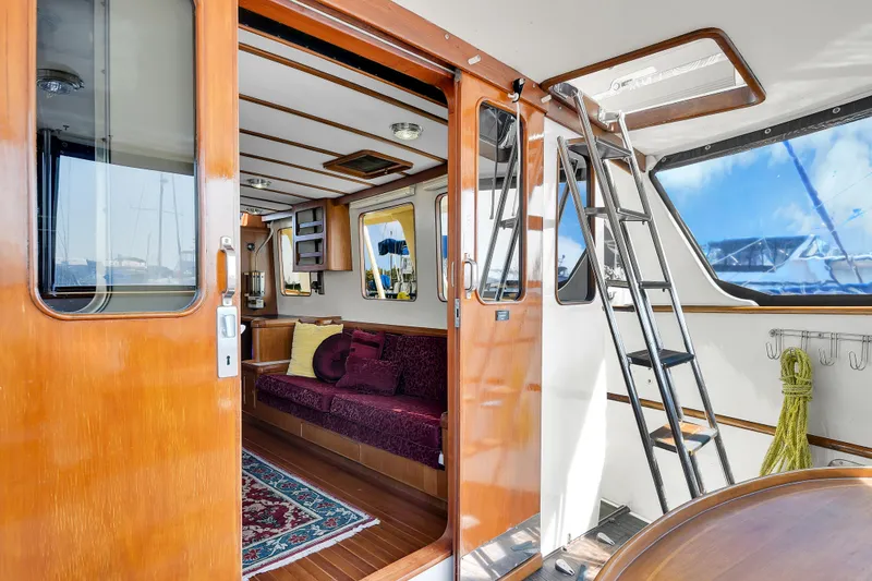 Slide: The Image of Interior of 1991 TransWorld Fantail 50 Motor Yacht with wooden finishes and cozy seating area. - 14