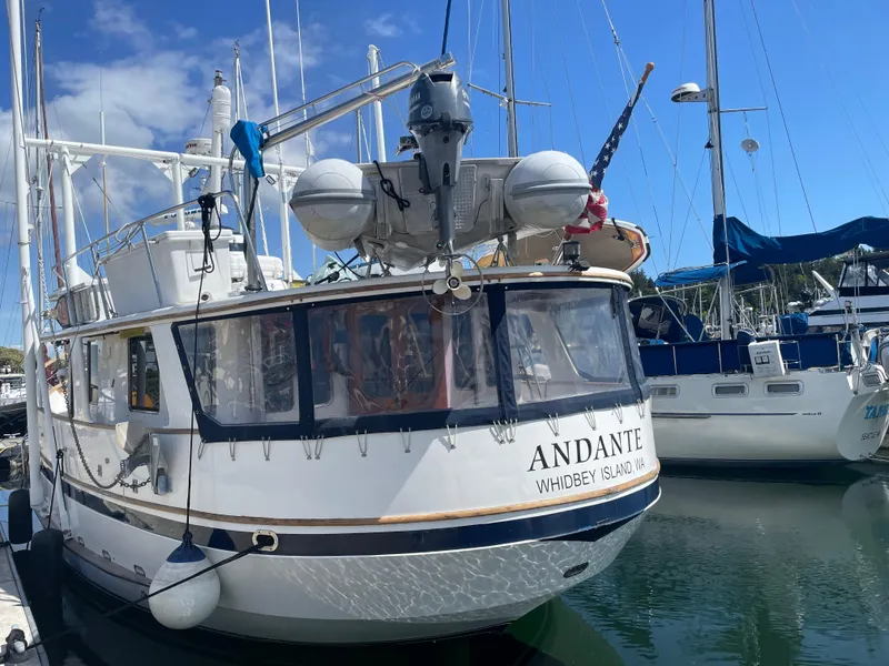 Slide: The Image of 1991 TransWorld Fantail 50 Motor Yacht docked at marina, named "Andante." - 2
