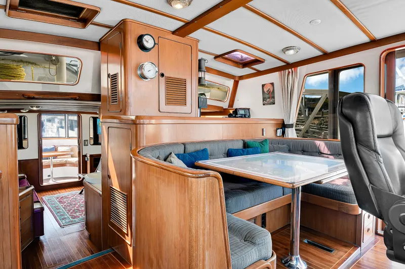 Slide: The Image of Interior of 1991 TransWorld Fantail 50 Motor Yacht with cozy dining area and wooden accents. - 5