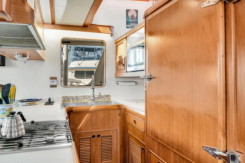 Slide: The Image of Interior of 1991 TransWorld Fantail 50 Motor Yacht kitchen with wooden cabinetry and stove. - 9