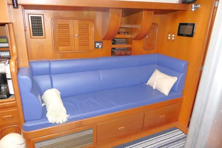Slide: The Image of Luxurious 2002 Tayana 460 Vancouver Pilothouse interior with blue seating and wooden accents. - 12