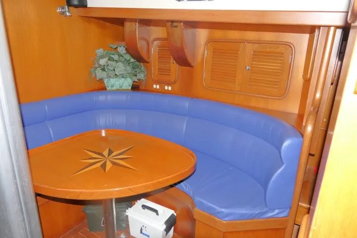 Slide: The Image of 2002 Tayana 460 Vancouver Pilothouse interior with blue seating and wooden table. - 13