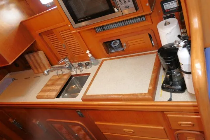 Slide: The Image of 2002 Tayana 460 Vancouver Pilothouse kitchen with sink, microwave, and coffee maker. - 16