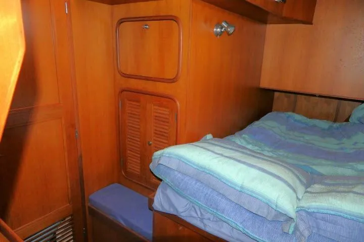 Slide: The Image of Cozy cabin interior of 2002 Tayana 460 Vancouver Pilothouse with wooden cabinetry and bedding. - 25