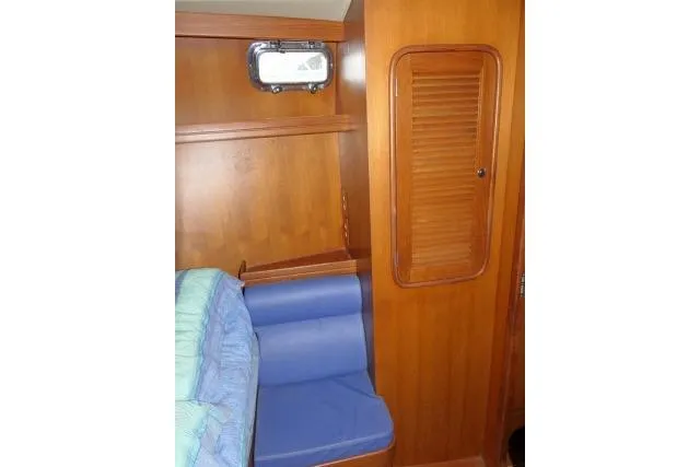 Slide: The Image of 2002 Tayana 460 Vancouver Pilothouse interior with wooden cabinetry and blue seating. - 27
