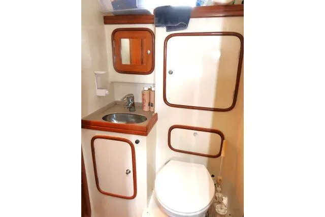 Slide: The Image of 2002 Tayana 460 Vancouver Pilothouse bathroom with sink, toilet, and wooden accents. - 30