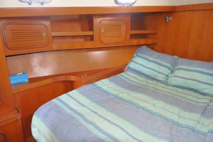 Slide: The Image of Cozy bedroom in 2002 Tayana 460 Vancouver Pilothouse with wooden cabinetry and striped bedding. - 36