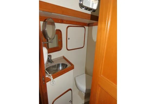 Slide: The Image of 2002 Tayana 460 Vancouver Pilothouse bathroom with sink, mirror, and toilet. - 40