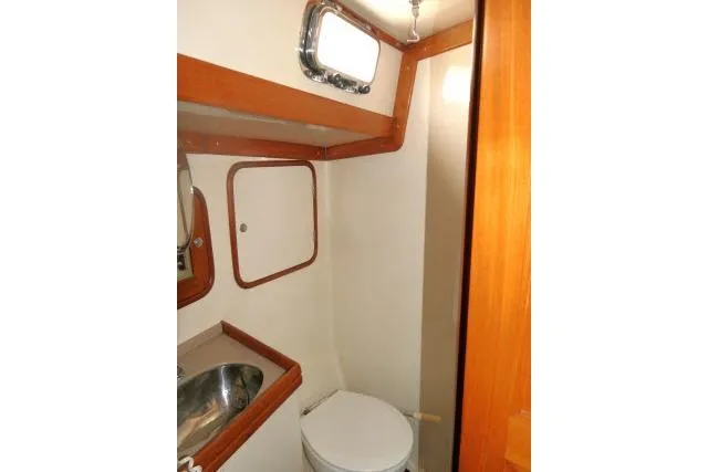 Slide: The Image of 2002 Tayana 460 Vancouver Pilothouse bathroom with sink, toilet, and wooden accents. - 41