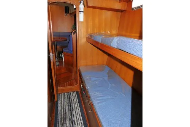 Slide: The Image of 2002 Tayana 460 Vancouver Pilothouse interior with wooden bunk beds and blue cushions. - 45