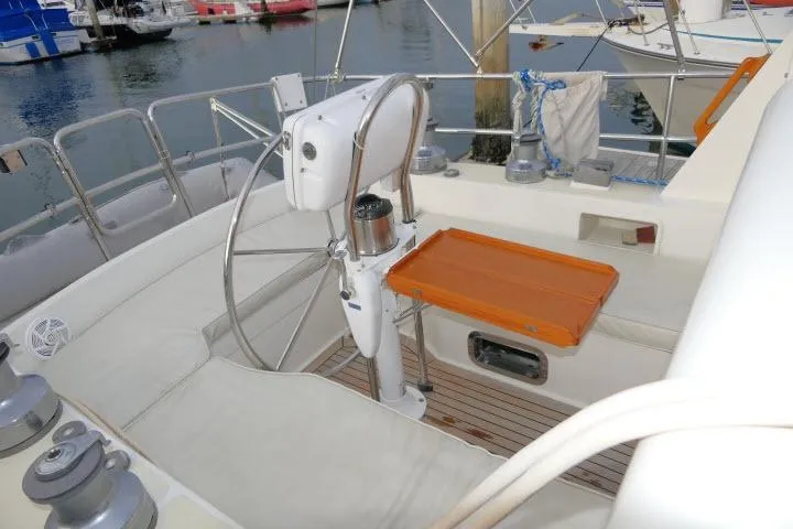 Slide: The Image of 2002 Tayana 460 Vancouver Pilothouse yacht cockpit with steering wheel and orange table. - 49