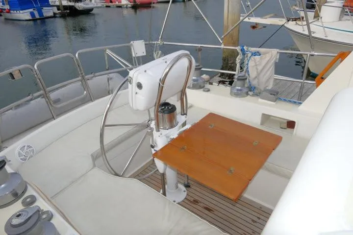 Slide: The Image of Cockpit of 2002 Tayana 460 Vancouver Pilothouse with steering wheel and wooden table. - 50