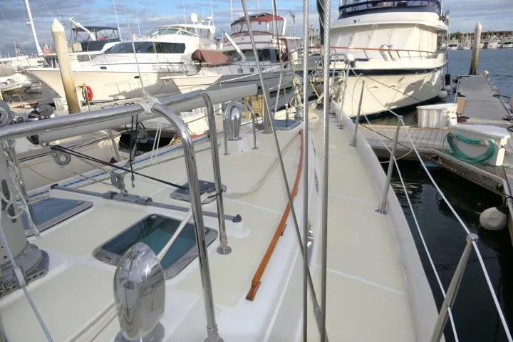 Slide: The Image of 2002 Tayana 460 Vancouver Pilothouse yacht docked at marina, surrounded by other boats. - 64