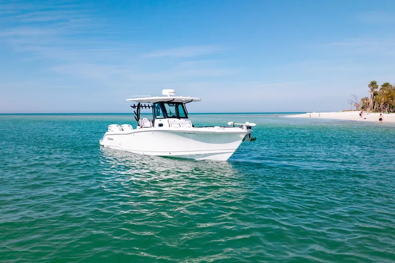 Slide: The Image of 2022 Crevalle 33 CSF boat on clear turquoise water near a sandy beach. - 20