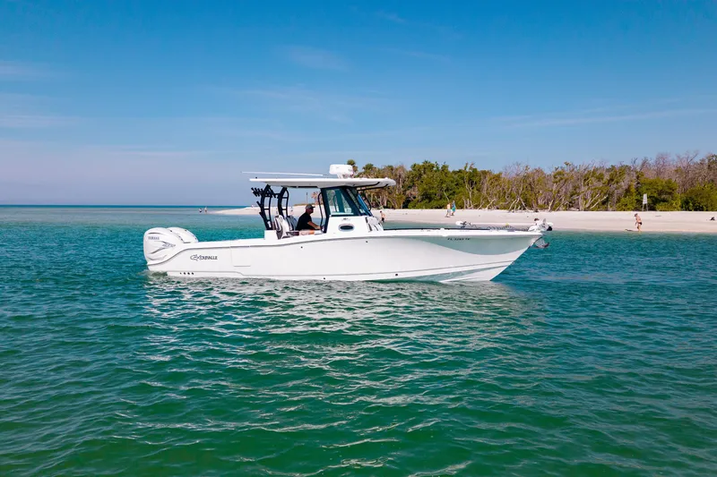 Slide: The Image of 2022 Crevalle 33 CSF boat on clear blue water near a sandy beach. - 21