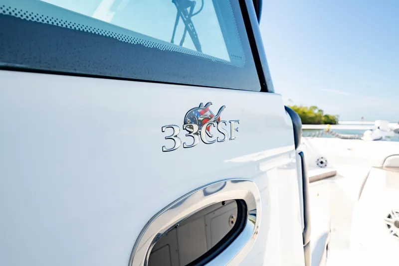Slide: The Image of 2022 Crevalle 33 CSF boat detail with logo, docked under clear blue sky. - 36