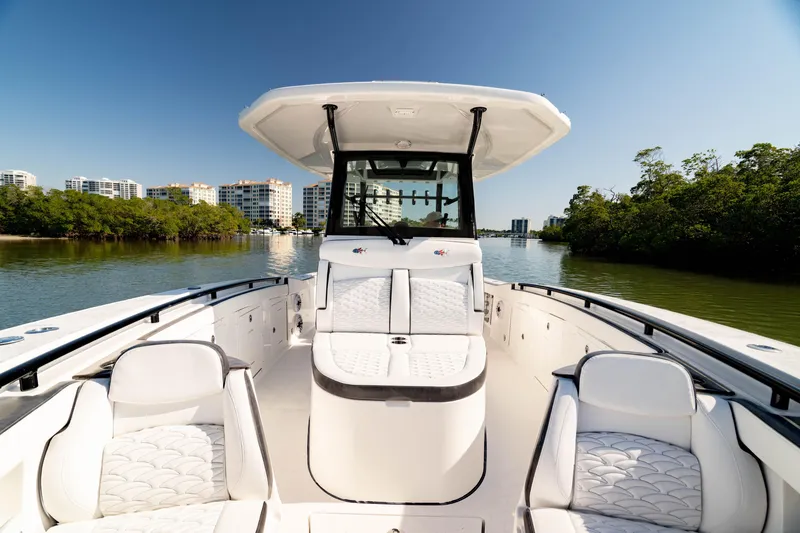 Slide: The Image of 2022 Crevalle 33 CSF boat on calm water, surrounded by greenery and buildings. - 4