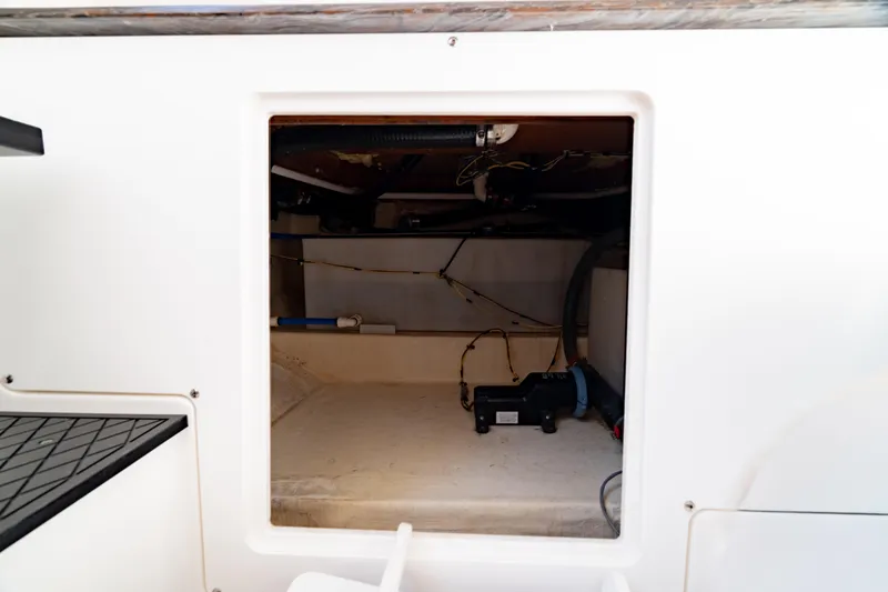 Slide: The Image of 2022 Crevalle 33 CSF boat storage compartment with visible wiring and equipment. - 60