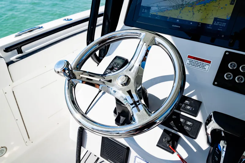 Slide: The Image of 2022 Crevalle 33 CSF boat helm with chrome steering wheel and navigation display. - 75