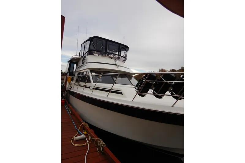 Slide: The Image of 1988 Camargue 48 Cockpit Motor Yacht docked, showcasing sleek design and spacious deck. - 10