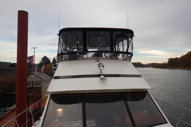Slide: The Image of 1988 Camargue 48 Cockpit Motor Yacht docked by a scenic river. - 11