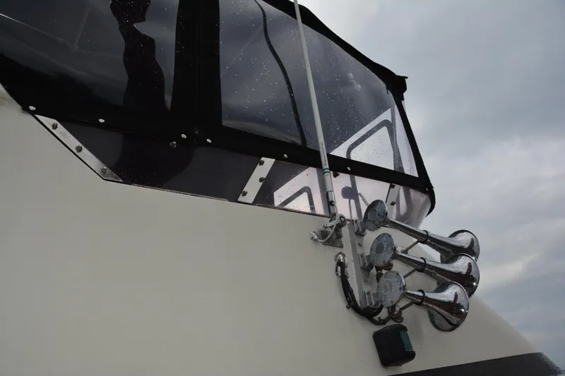 Slide: The Image of 1988 Camargue 48 Cockpit Motor Yacht with chrome horns and rain-speckled windows. - 14