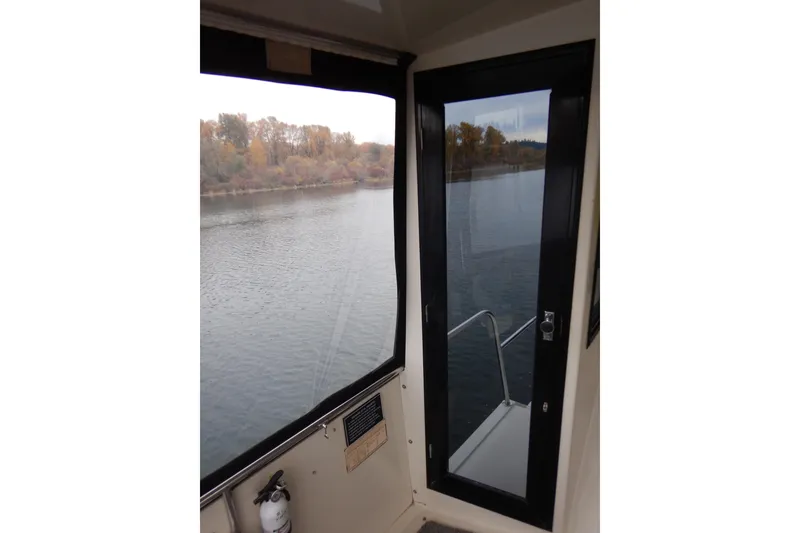 Slide: The Image of 1988 Camargue 48 Cockpit Motor Yacht interior view with river scenery. - 15