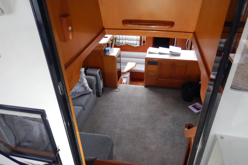Slide: The Image of Interior of 1988 Camargue 48 Cockpit Motor Yacht with cozy seating and wooden cabinetry. - 16