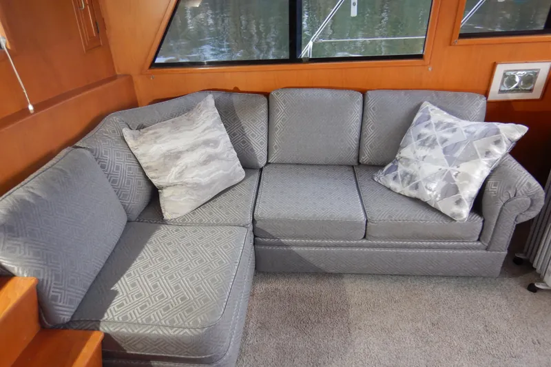 Slide: The Image of Gray sofa with patterned cushions inside a 1988 Camargue 48 Cockpit Motor Yacht. - 17