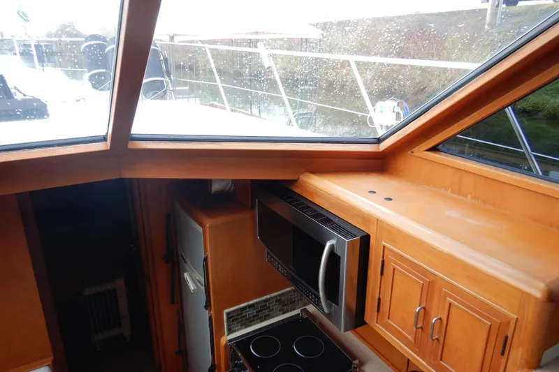 Slide: The Image of Interior of 1988 Camargue 48 Cockpit Motor Yacht with control panel and cozy seating area. - 21
