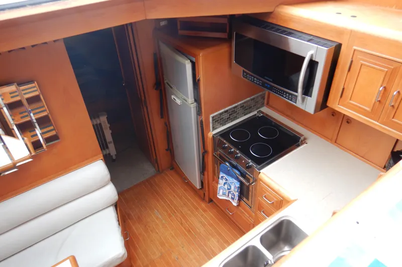 Slide: The Image of Interior of 1988 Camargue 48 Cockpit Motor Yacht with wooden flooring and dining area. - 23