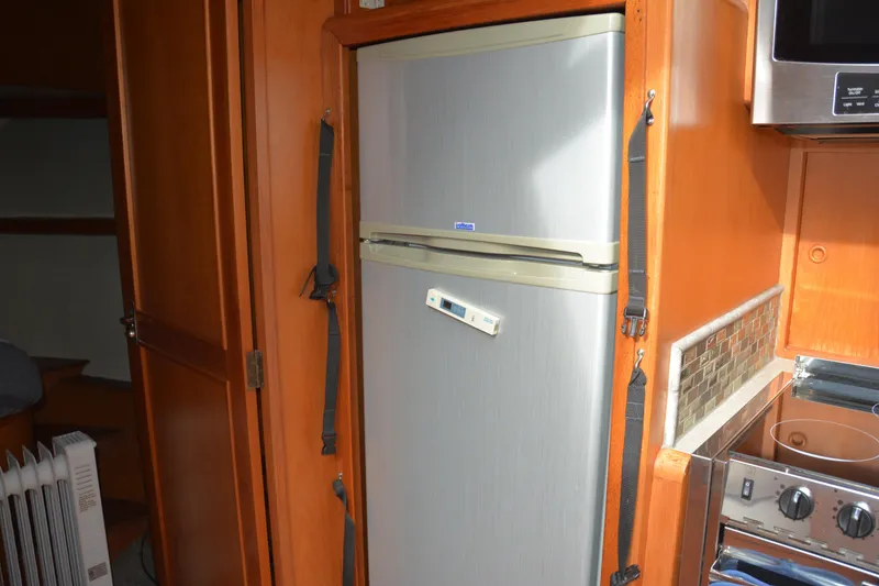 Slide: The Image of Open refrigerator inside 1988 Camargue 48 Cockpit Motor Yacht, showcasing spacious interior shelves. - 29