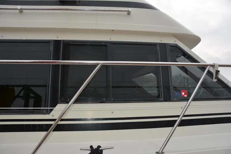 Slide: The Image of 1988 Camargue 48 Cockpit Motor Yacht side view with windows and railing. - 3