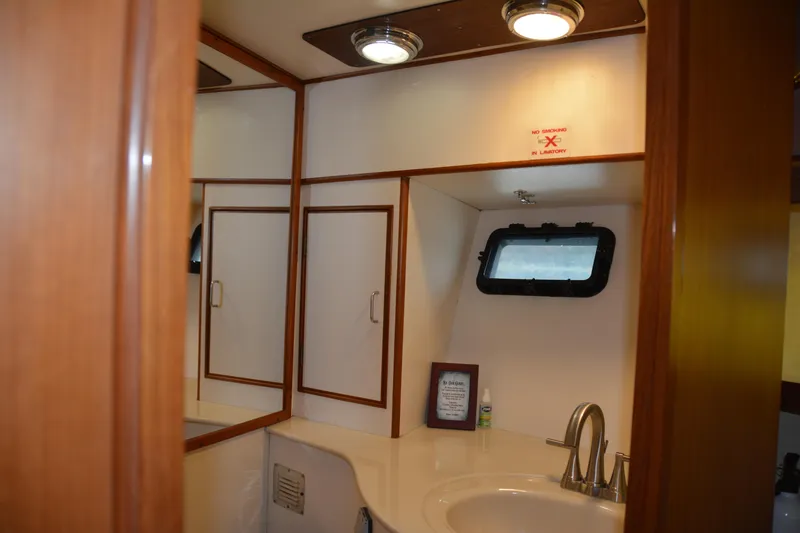 Slide: The Image of Bathroom interior of 1988 Camargue 48 Cockpit Motor Yacht with sink and porthole window. - 43