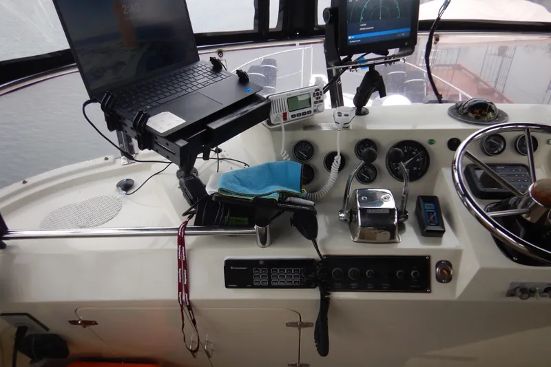 Slide: The Image of Laptop setup on 1988 Camargue 48 Cockpit Motor Yacht, near marine radio. - 56
