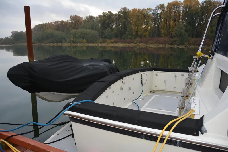 Slide: The Image of 1988 Camargue 48 Cockpit Motor Yacht docked by a serene, wooded shoreline. - 6