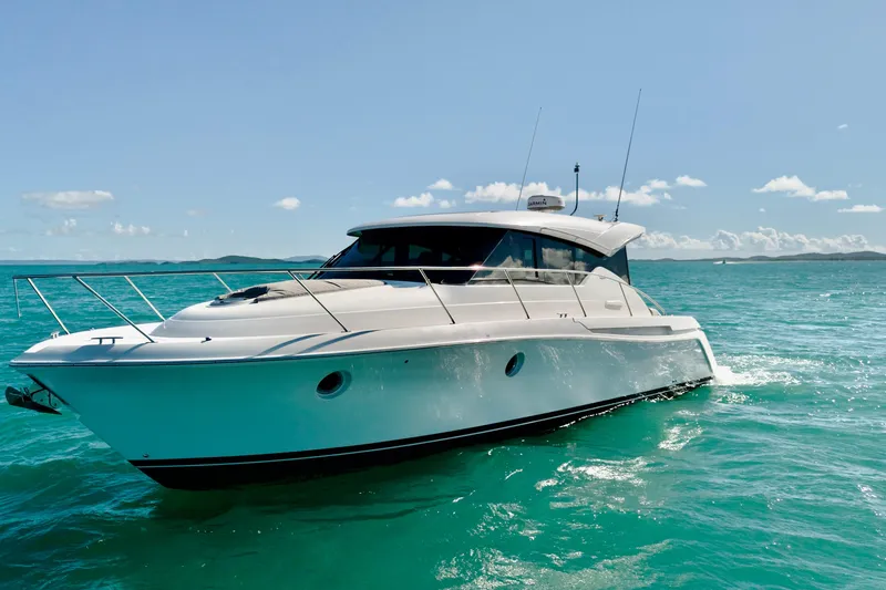 The Image of 2023 Tiara Yachts C39 Coupe cruising on turquoise waters under a clear sky. - 0