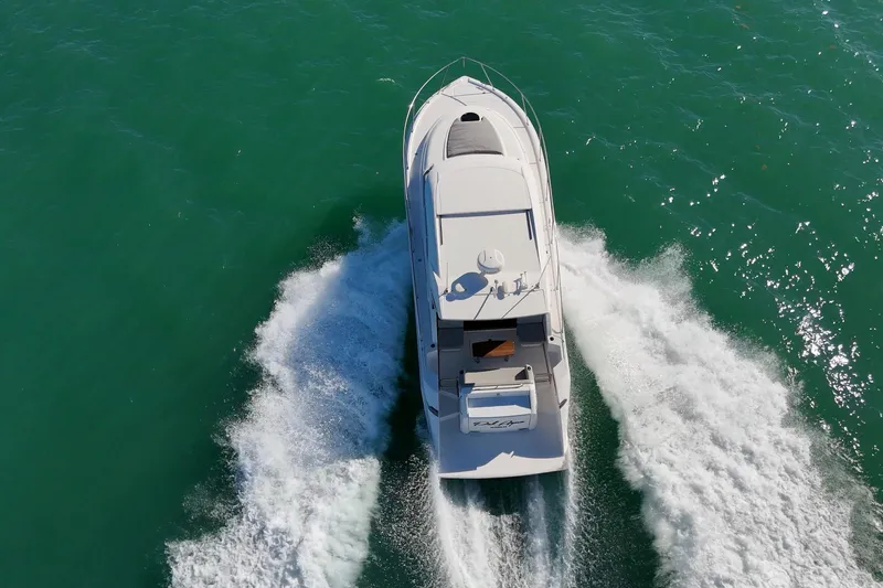 Slide: The Image of 2023 Tiara Yachts C39 Coupe cruising on turquoise water, aerial view. - 19