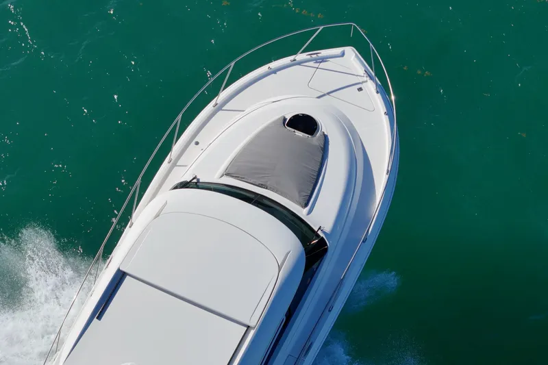 Slide: The Image of 2023 Tiara Yachts C39 Coupe cruising on turquoise water, aerial view. - 25