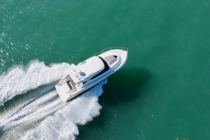 Slide: The Image of 2023 Tiara Yachts C39 Coupe cruising on turquoise water, aerial view. - 26