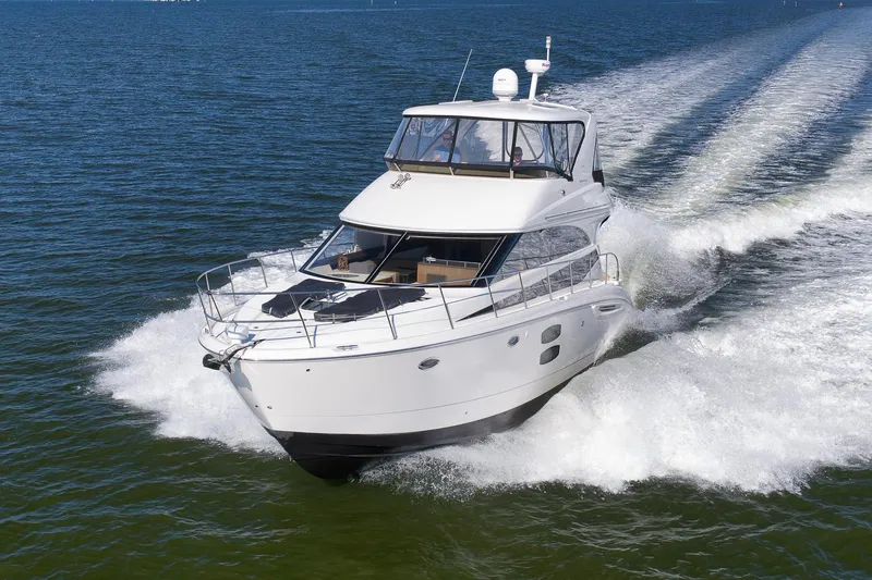 Slide: The Image of 2012 Meridian 441 Sedan yacht cruising on open water, creating a dynamic wake. - 17