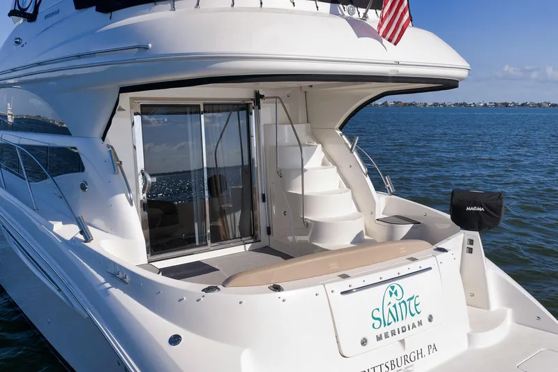 Slide: The Image of 2012 Meridian 441 Sedan yacht with American flag, docked on calm waters. - 27