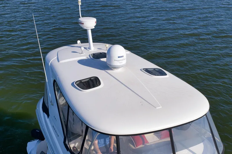 Slide: The Image of 2012 Meridian 441 Sedan yacht on water, featuring sleek white design and advanced navigation equipment. - 29